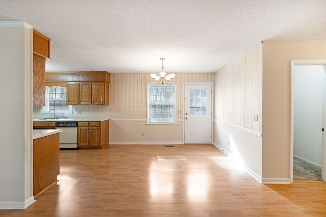 kitchen featuring a wealth of natural light, white dishwasher, and light hardwood / wood-style flooring