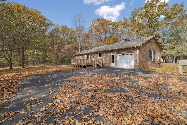 view of home's exterior with a garage and a wooden deck