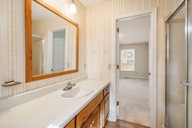 bathroom featuring vanity, wood-type flooring, and a shower with shower door