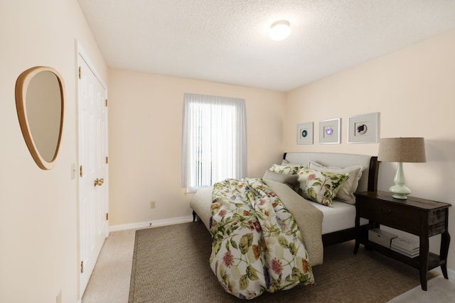 carpeted bedroom with a textured ceiling and a closet