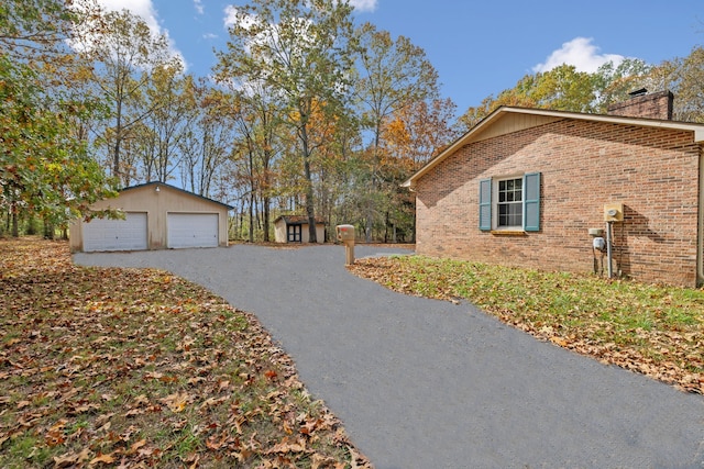 view of property exterior featuring a garage and an outdoor structure