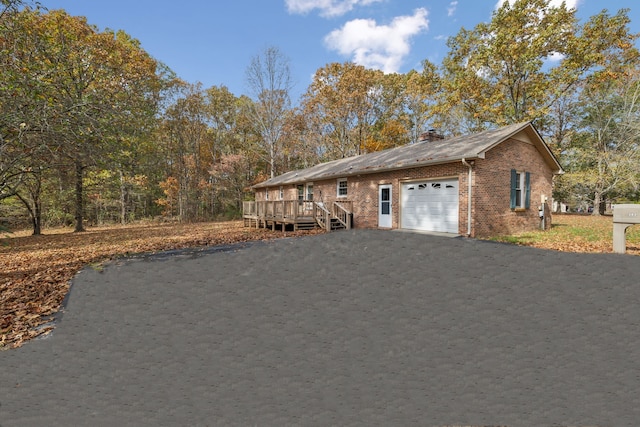 view of home's exterior featuring a garage and a wooden deck