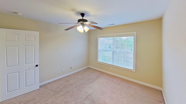 spare room featuring light colored carpet and ceiling fan