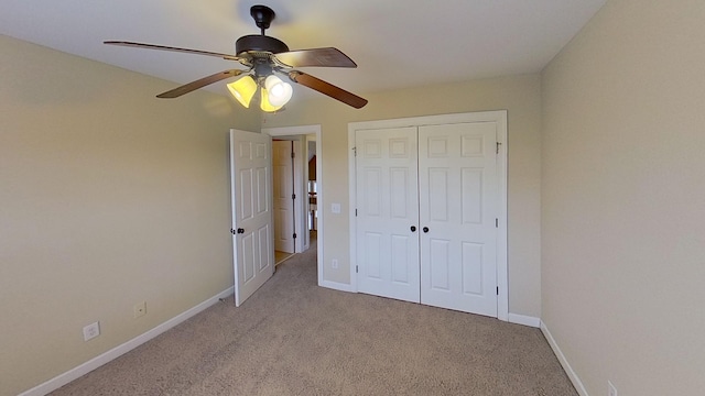 unfurnished bedroom with ceiling fan, a closet, and light carpet