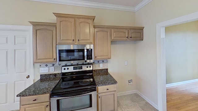 kitchen with light brown cabinets, crown molding, stainless steel appliances, and dark stone counters