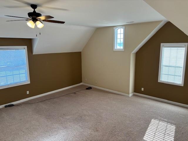 additional living space with light colored carpet, vaulted ceiling, and ceiling fan