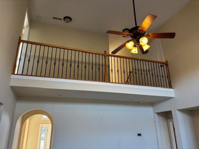 stairs featuring ceiling fan and a towering ceiling