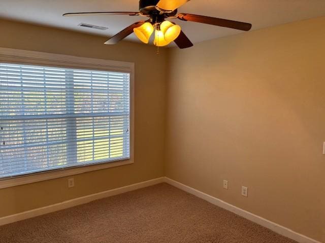 carpeted spare room with ceiling fan