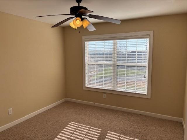 carpeted empty room featuring a wealth of natural light and ceiling fan