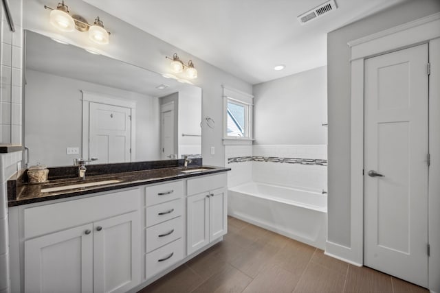 bathroom with vanity and a tub to relax in