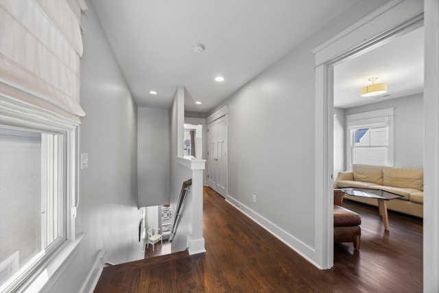 hallway with dark wood-type flooring and a healthy amount of sunlight