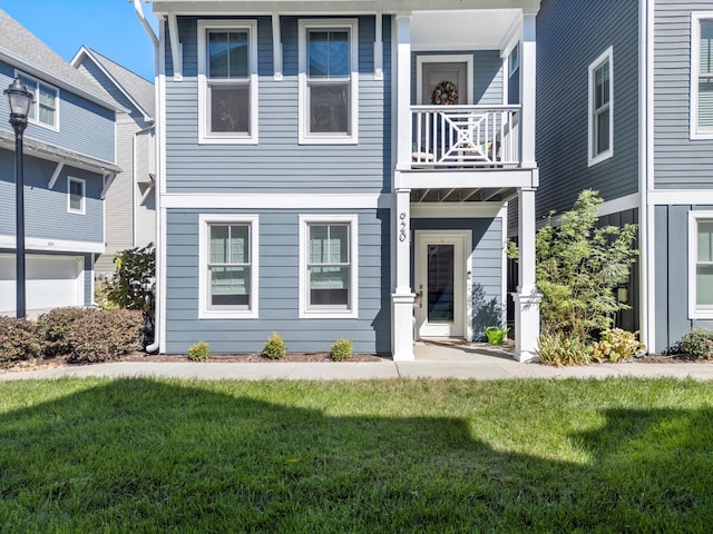 view of front facade featuring a front yard and a balcony