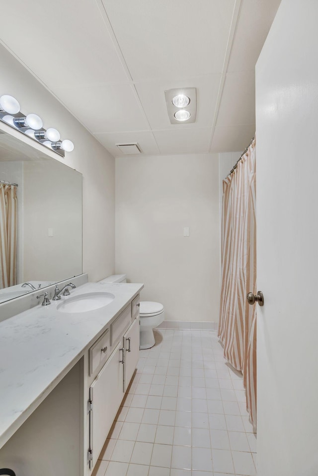 bathroom with toilet, vanity, and baseboards