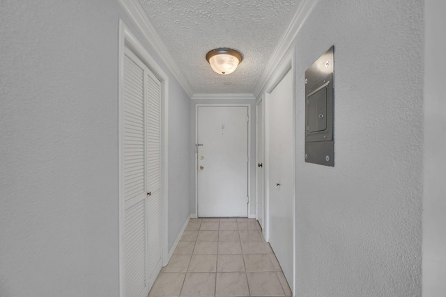 hallway featuring a textured ceiling, ornamental molding, and light tile patterned floors