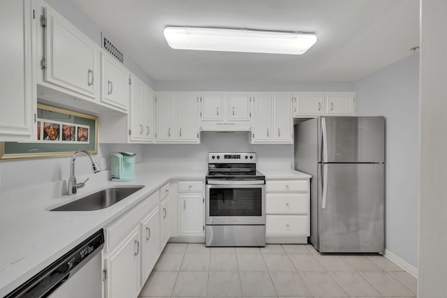 kitchen featuring light tile patterned floors, appliances with stainless steel finishes, sink, and white cabinets