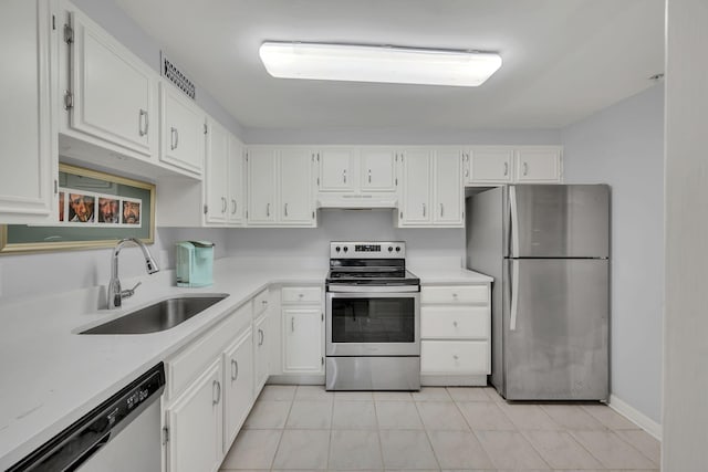 kitchen featuring appliances with stainless steel finishes, a sink, under cabinet range hood, white cabinetry, and light countertops