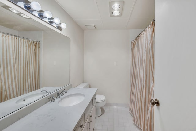 bathroom featuring tile patterned flooring, toilet, vanity, and baseboards