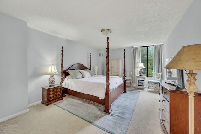 bedroom featuring light colored carpet, a textured ceiling, and baseboards