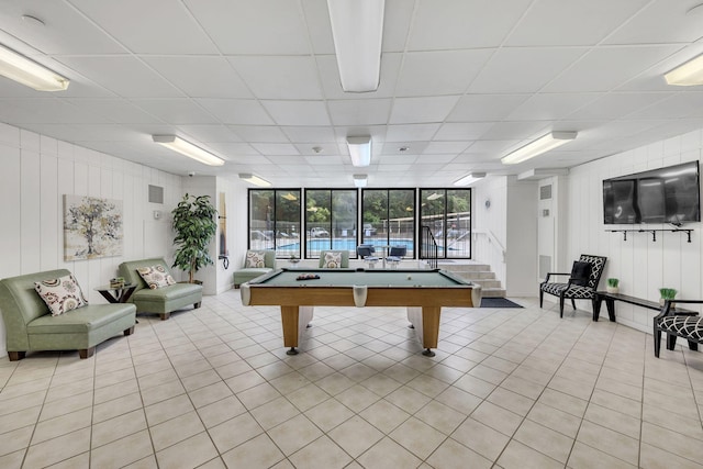 playroom featuring light tile patterned flooring, a paneled ceiling, billiards table, and a decorative wall