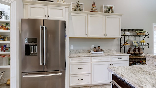 kitchen featuring high end refrigerator and light stone counters