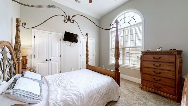 bedroom featuring a closet, light colored carpet, and vaulted ceiling