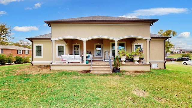 rear view of house with covered porch and a lawn