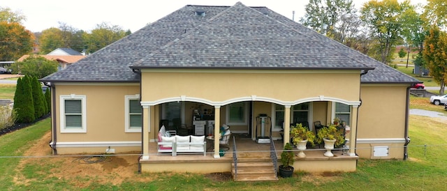 rear view of property featuring a lawn