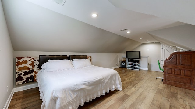 bedroom with vaulted ceiling and hardwood / wood-style floors