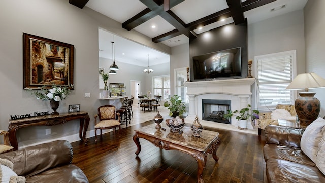 living room featuring beam ceiling, coffered ceiling, wood-type flooring, and plenty of natural light