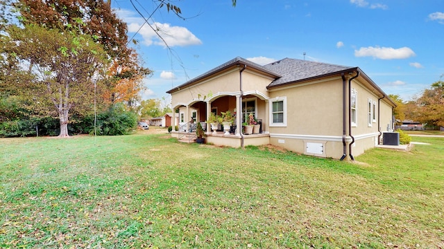 back of property with central AC and a lawn