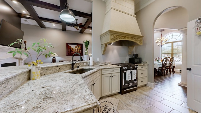 kitchen with high end stainless steel range oven, sink, light wood-type flooring, pendant lighting, and light stone counters