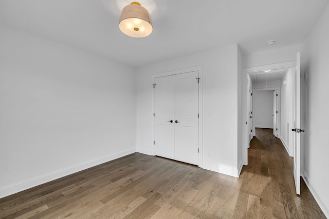 unfurnished bedroom with a closet and hardwood / wood-style floors