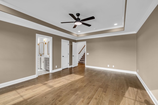 unfurnished room with ornamental molding, a raised ceiling, hardwood / wood-style flooring, and ceiling fan