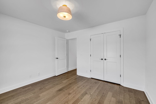 unfurnished bedroom featuring hardwood / wood-style flooring and a closet