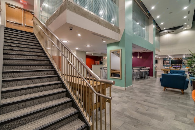 staircase featuring a towering ceiling