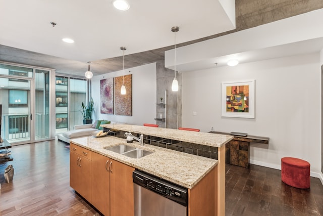 kitchen featuring a center island with sink, dark hardwood / wood-style floors, dishwasher, pendant lighting, and sink