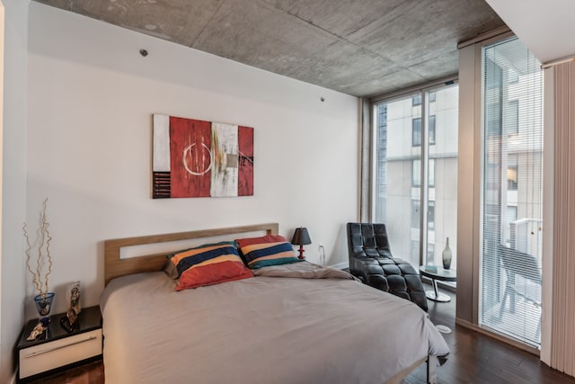 bedroom with dark hardwood / wood-style floors and floor to ceiling windows