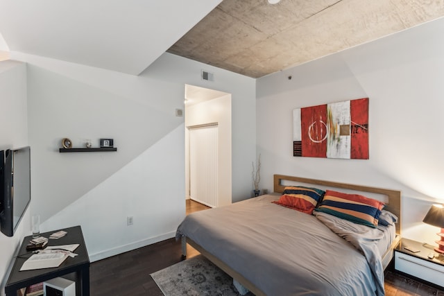 bedroom with dark hardwood / wood-style flooring