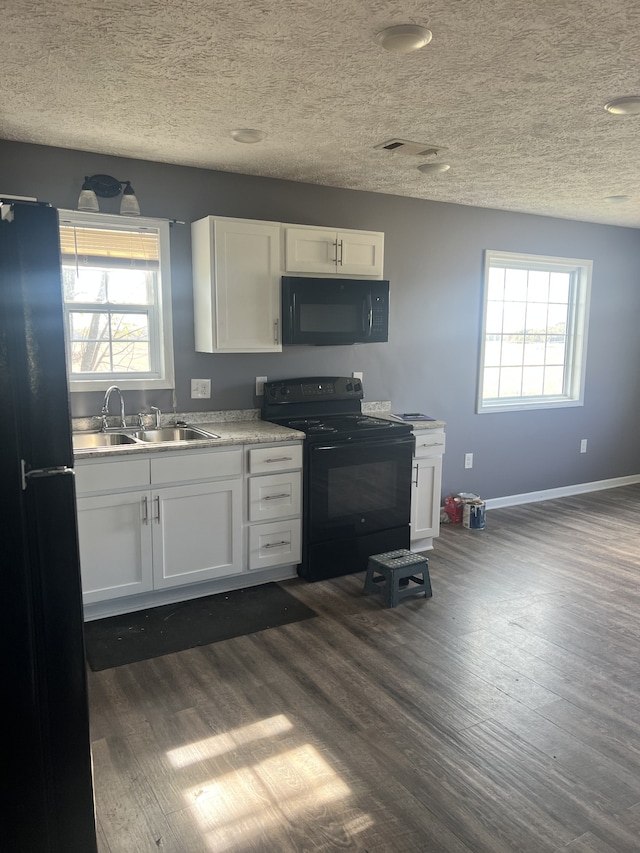 kitchen with white cabinets, black appliances, sink, and dark hardwood / wood-style flooring