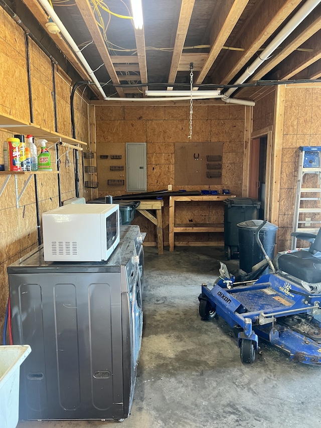 basement with washer / dryer, a workshop area, and electric panel