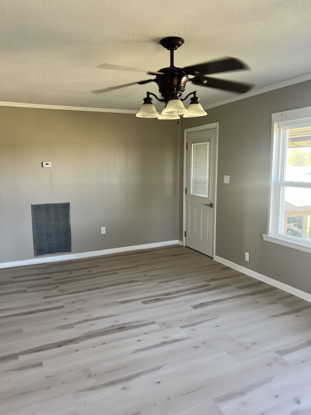 spare room featuring crown molding, light wood-type flooring, and ceiling fan