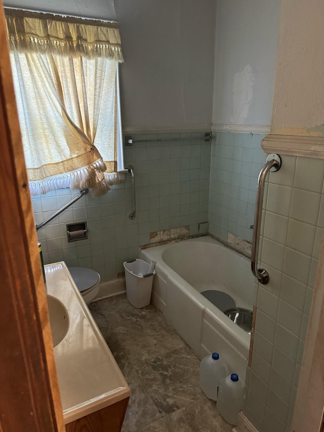 bathroom featuring a bathtub, toilet, tile walls, and vanity