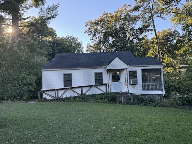 view of front of house with a front yard and cooling unit