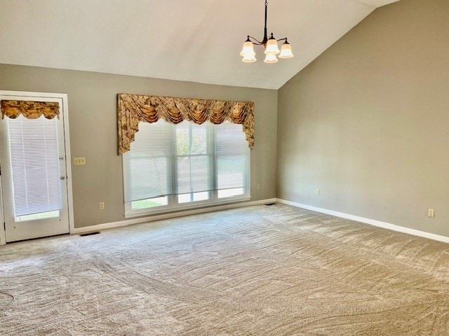 empty room featuring high vaulted ceiling, light carpet, and a chandelier