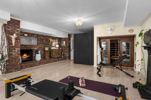 workout area featuring light hardwood / wood-style floors and a fireplace