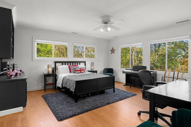 bedroom featuring ceiling fan, crown molding, and light hardwood / wood-style floors