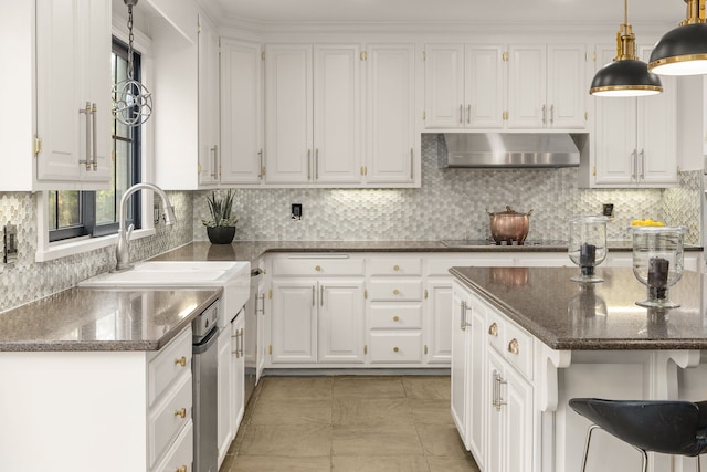 kitchen with a kitchen island, white cabinetry, wall chimney exhaust hood, decorative light fixtures, and sink