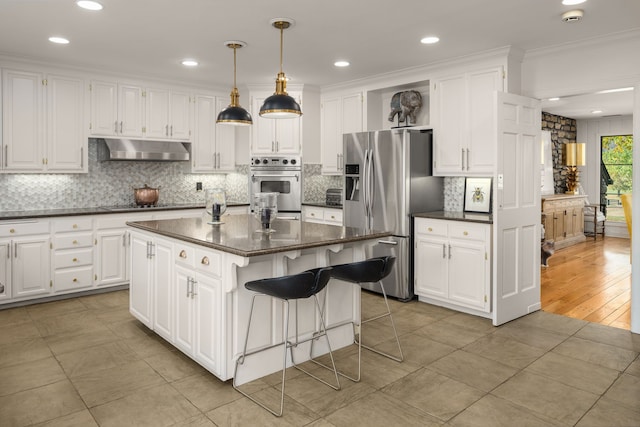 kitchen featuring crown molding, a kitchen island, white cabinetry, and stainless steel appliances