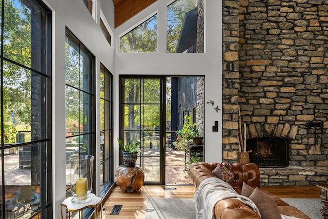 interior space with a stone fireplace and lofted ceiling