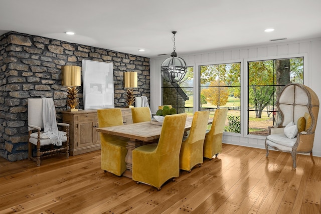 dining space with light hardwood / wood-style flooring, a chandelier, and plenty of natural light